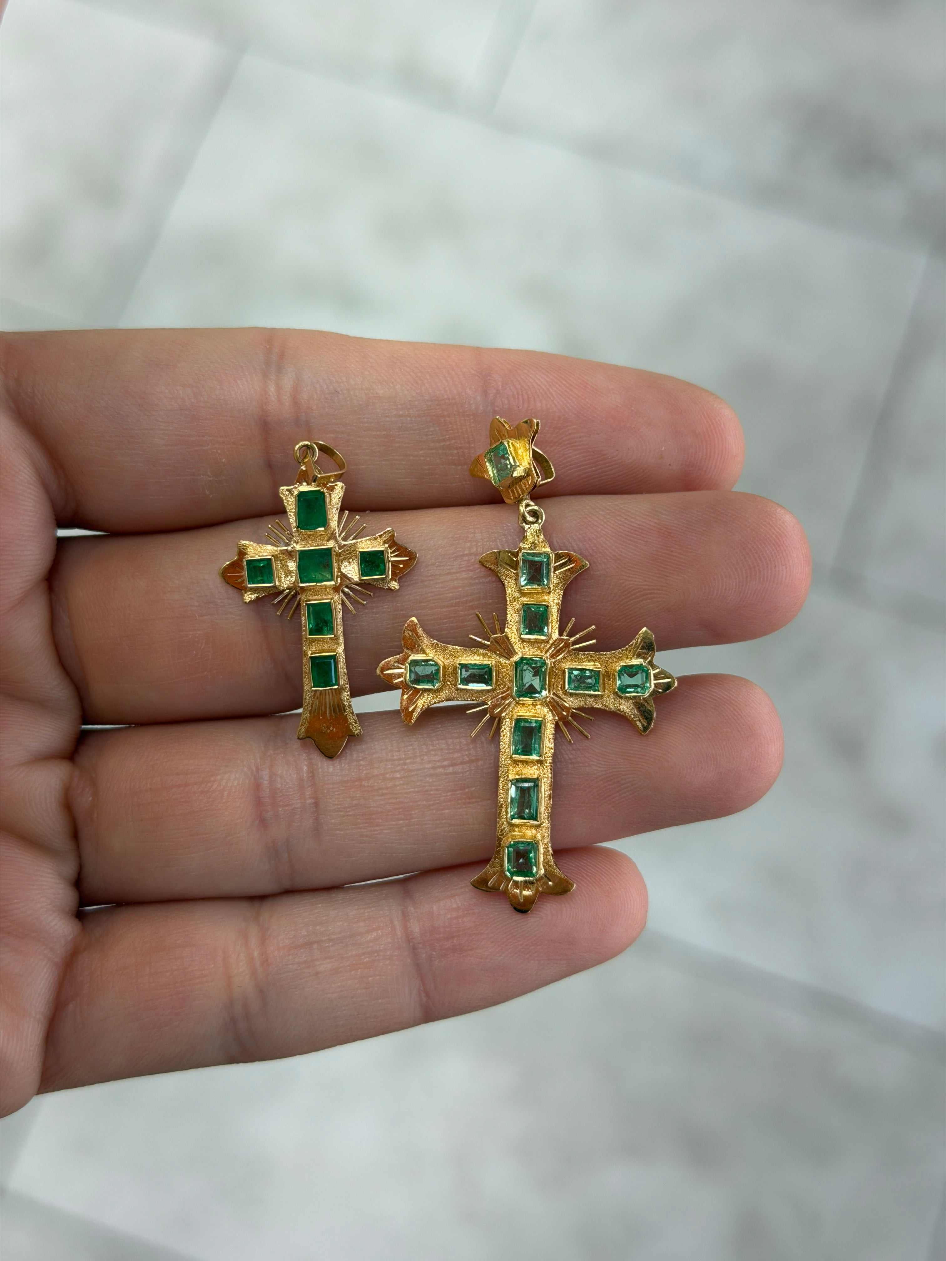 Pre Columbian inspired 18K gold crosses with bezel-set Colombian emerald cuts in small and large sizes