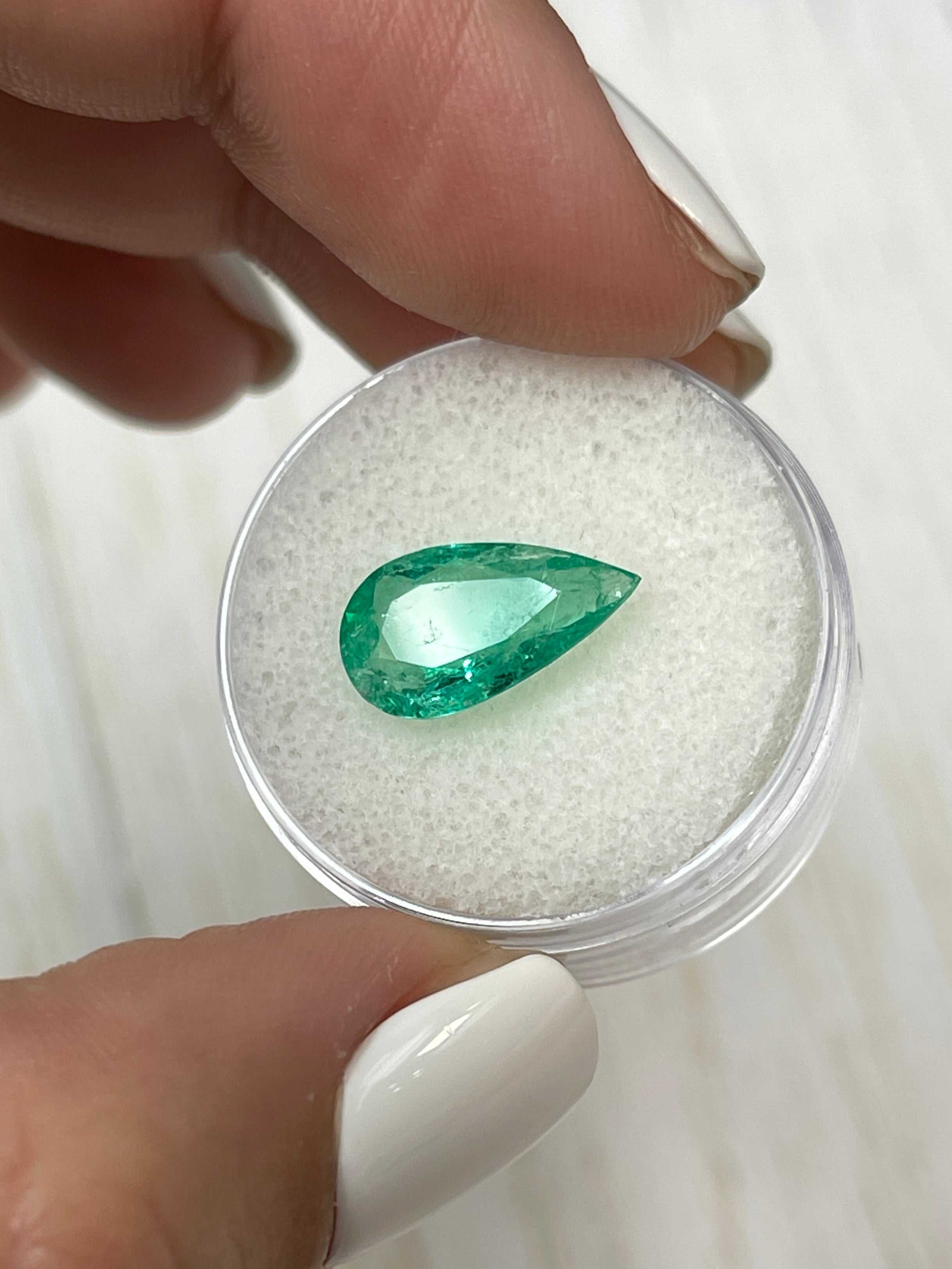 Natural 2.61 carat Colombian emerald loose gemstone with pear cut, displayed on a white background, from JR Colombian Emeralds.