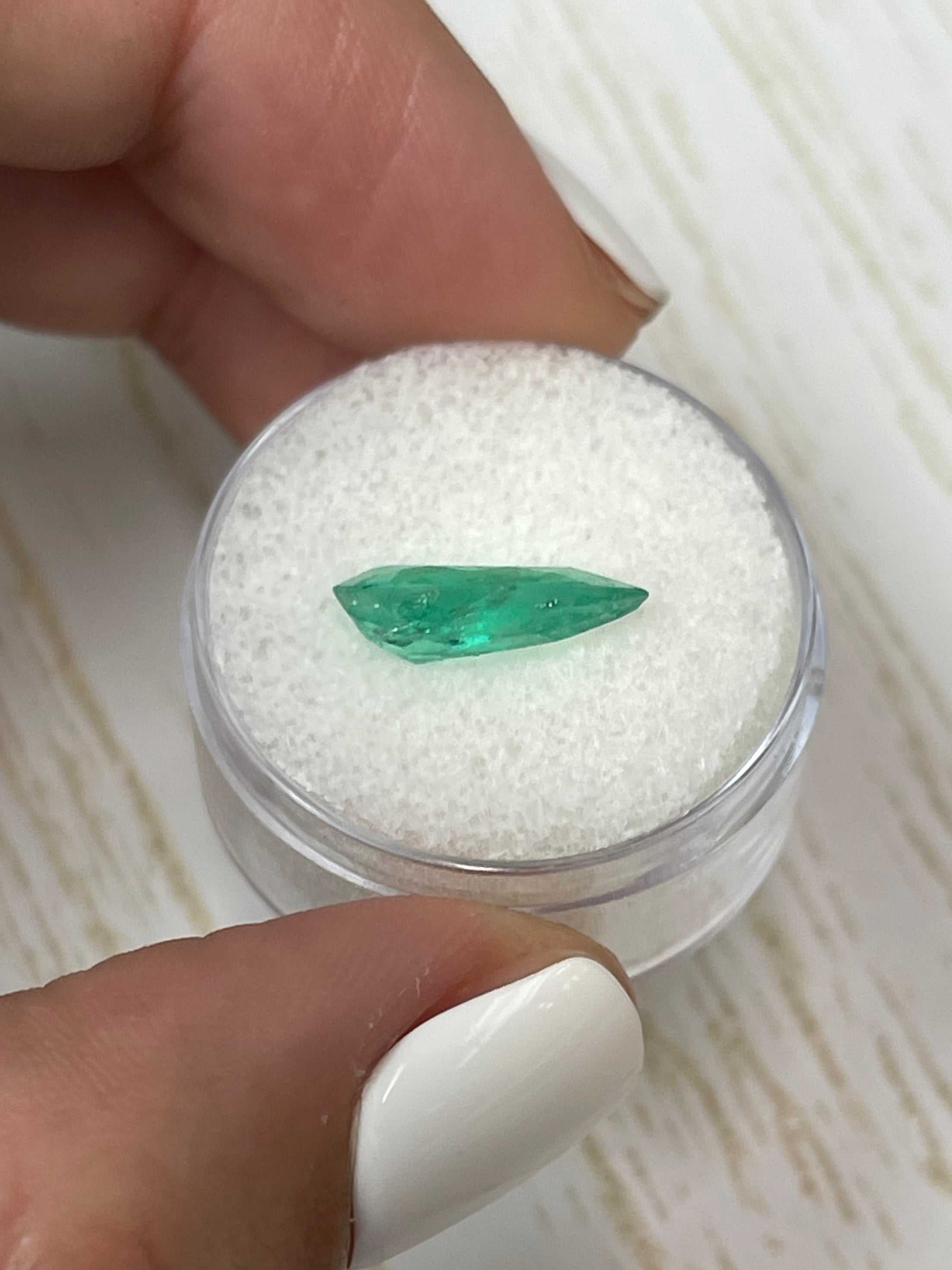 Two 2.61 carat natural Colombian emeralds in pear cut with green color, showcased as loose gemstones from JR Colombian Emeralds.
