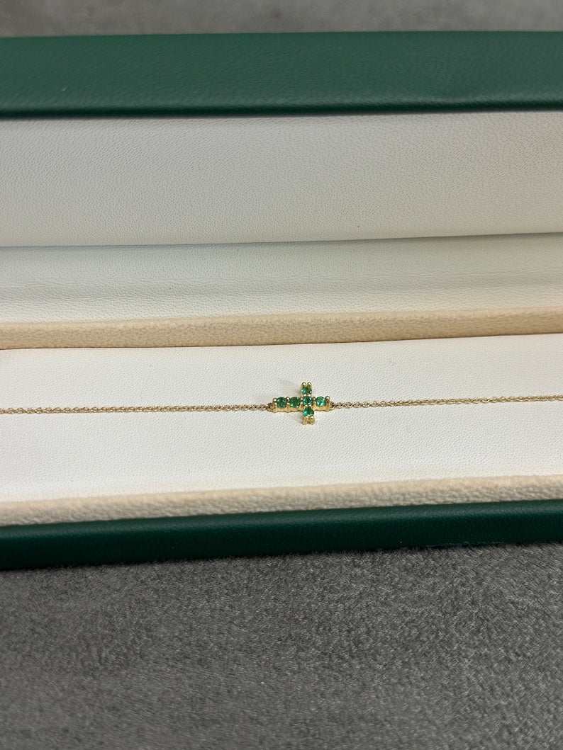 14K gold cross bracelet featuring a vivid medium green natural emerald, 0.20tcw, from Colombian Emerald.