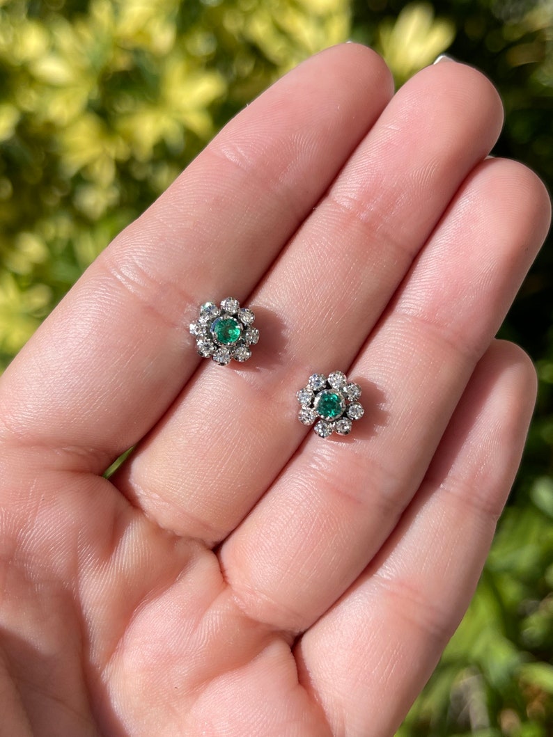 Colombian Emerald floral stud earrings with round cut diamonds, 14K gold, featuring 0.44tcw emeralds and diamond accents.