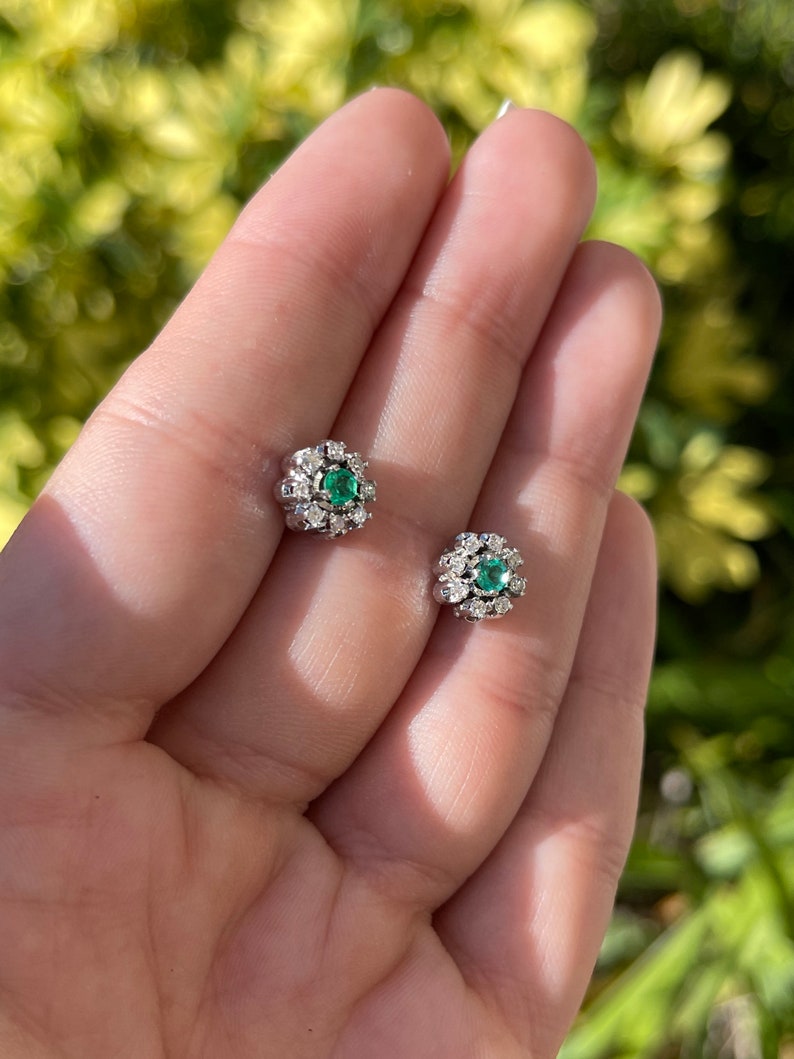 Colombian Emerald floral stud earrings with round-cut diamonds and 14K gold setting, featuring vibrant green emeralds and sparkling accents.