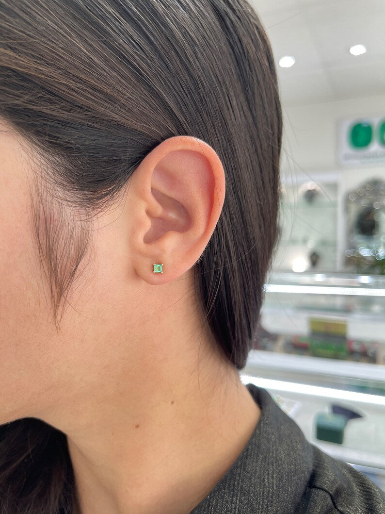 Natural 0.45tcw petite Colombian emerald princess Asscher cut stud earrings in 14K gold.