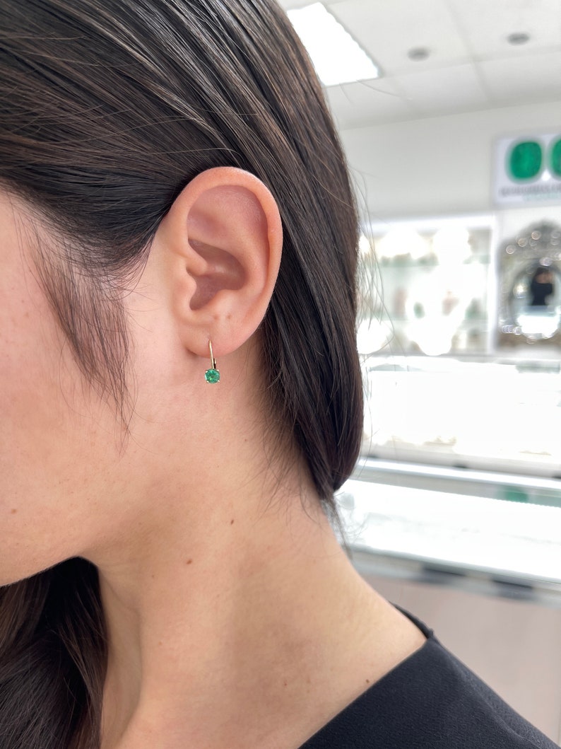 14K yellow gold emerald leverback earrings featuring round Colombian emeralds with 0.80 carat total weight, elegant and sparkling.