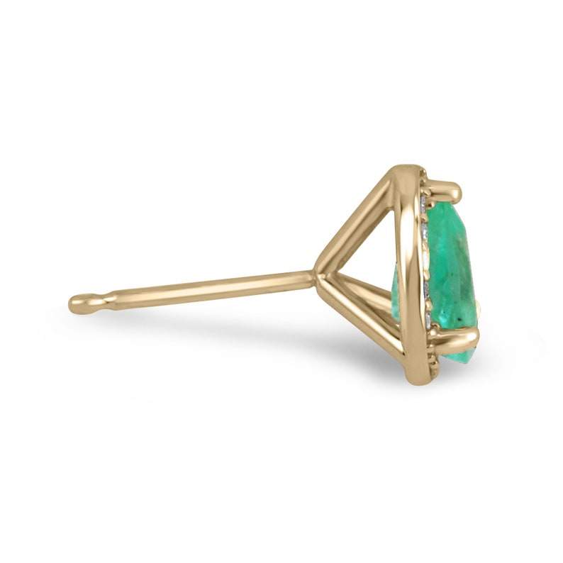 Colombian Emerald and diamond halo pear cut earrings in 14K gold featuring 1.07 carats of natural emeralds and sparkling diamonds.
