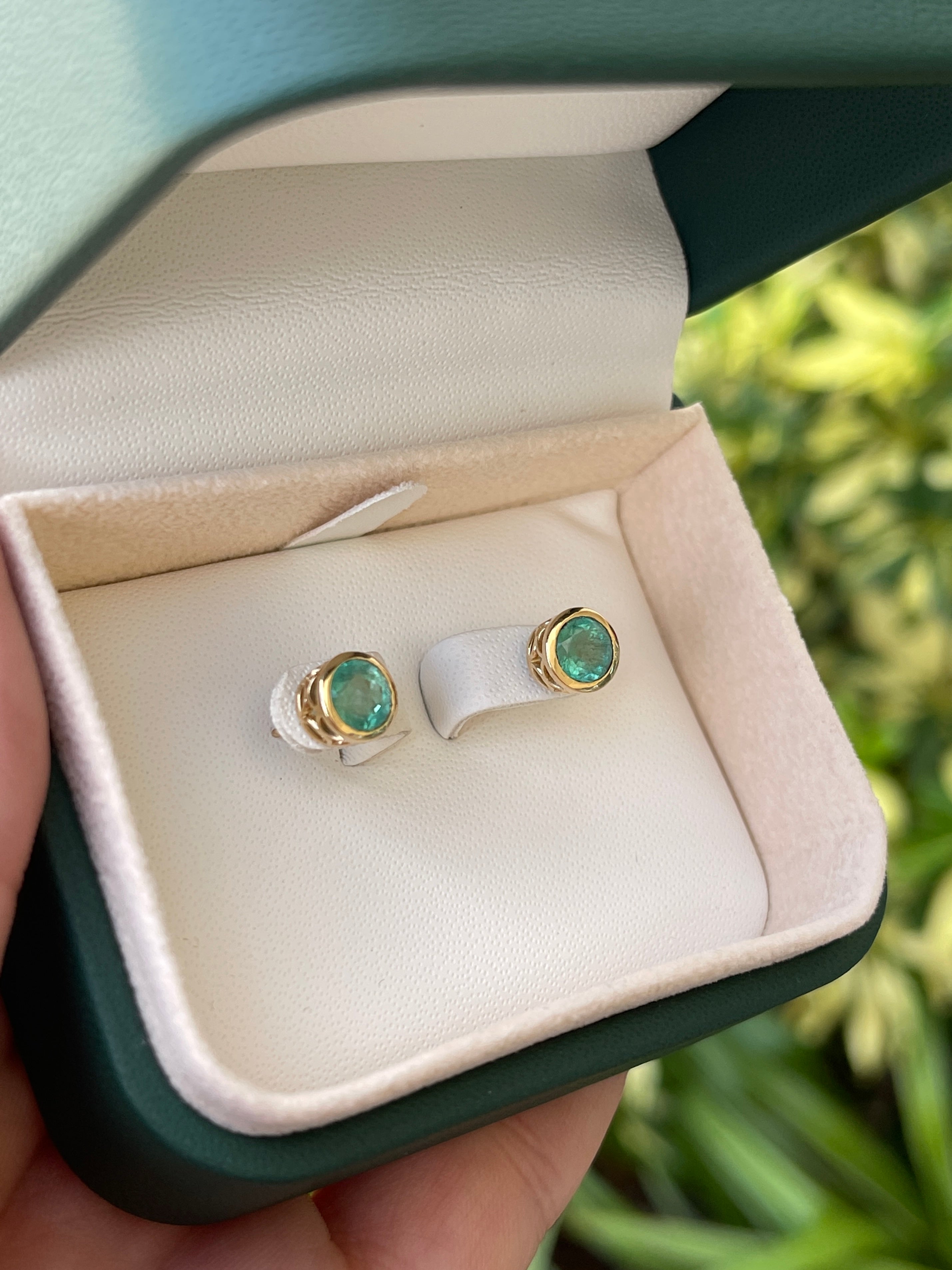 Colombian Emerald earrings with 1.60tcw round cut natural emeralds and 14K gold push back setting, showcasing elegant jewelry design.