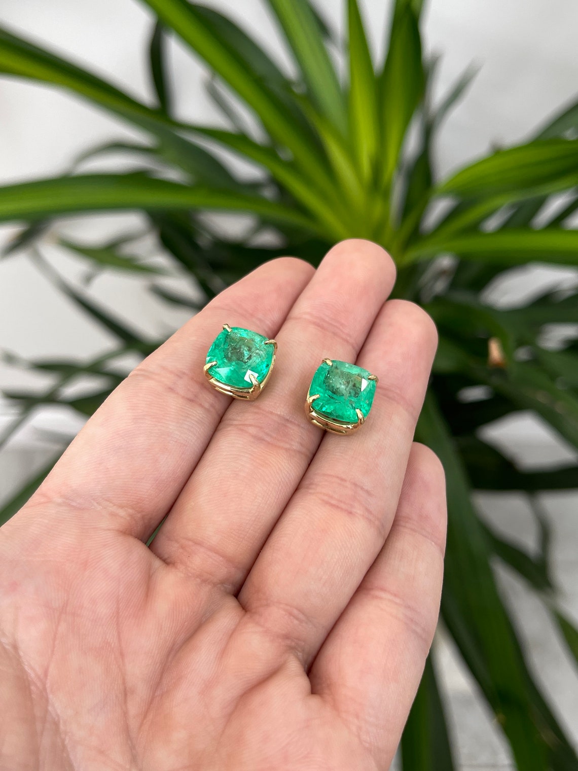 Colombian Emerald earrings with 11.80tcw AAA cushion cut emeralds in 18K gold with four-claw prong settings.