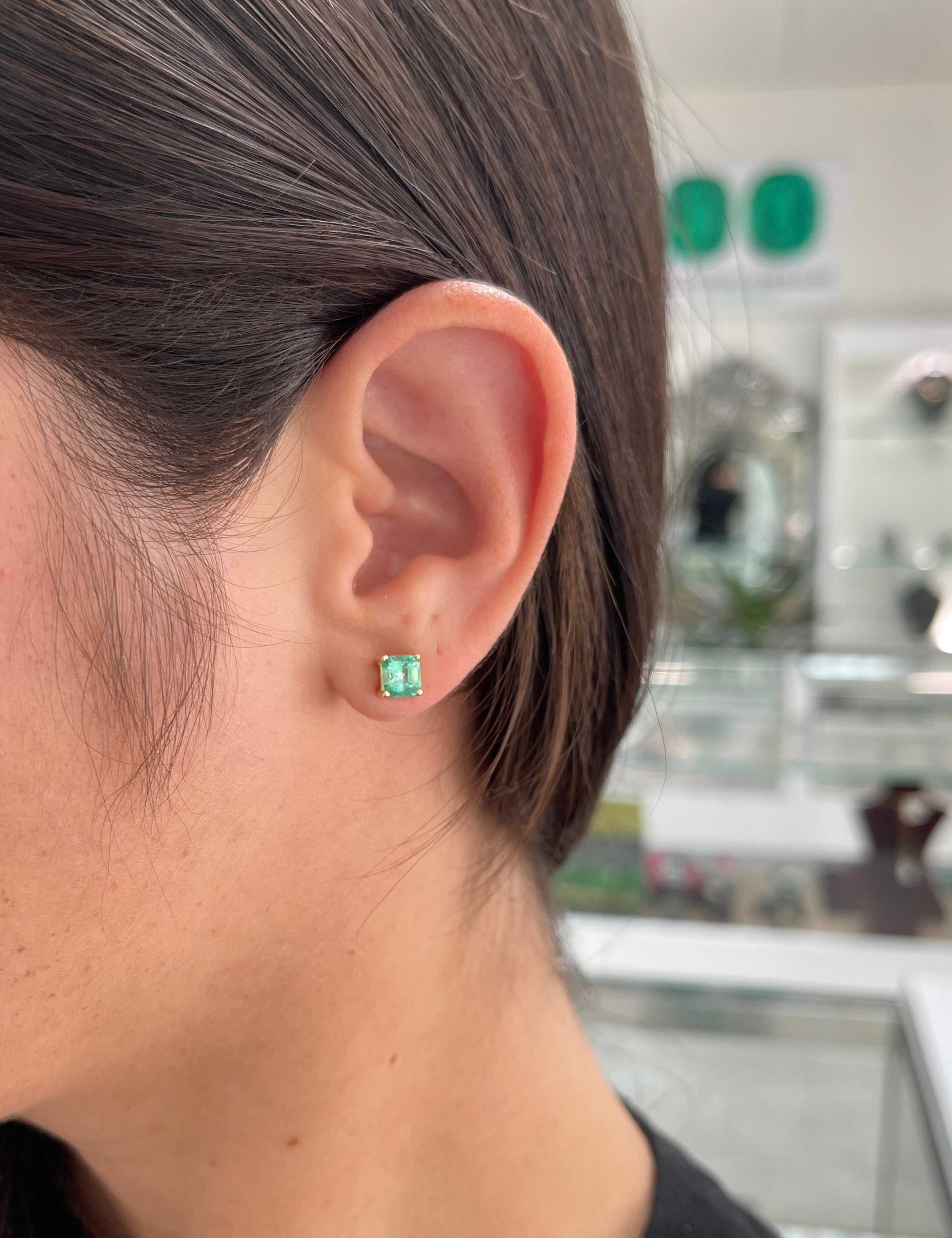 Colombian Emerald 2.05tcw Asscher cut emerald screw back stud earrings in 14K gold, featuring square-shaped vibrant green gemstones.