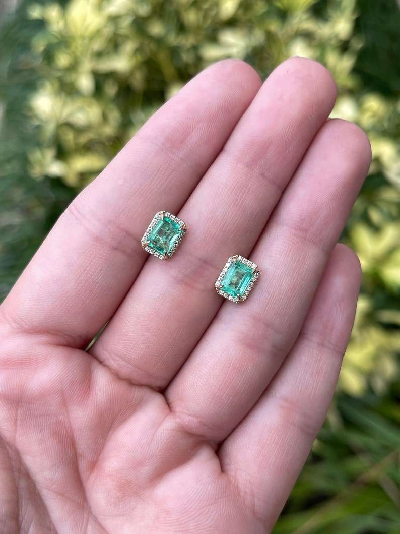 Colombian Emerald earrings featuring 2.10 tcw 14K gold classic natural emerald-cut diamond halo stud earrings.