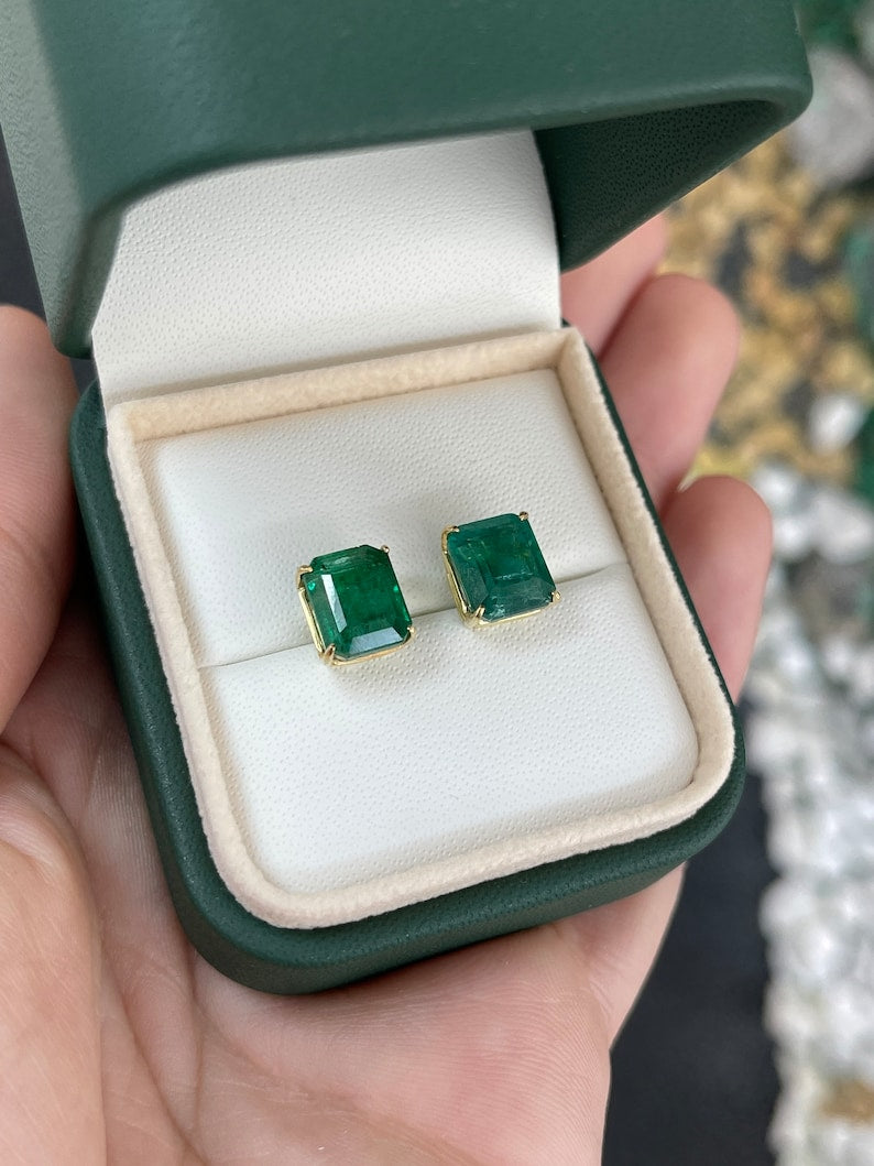 Natural Colombian emerald stud earrings with 6.63tcw in 18K gold, featuring large, rare emeralds in four-prong settings.