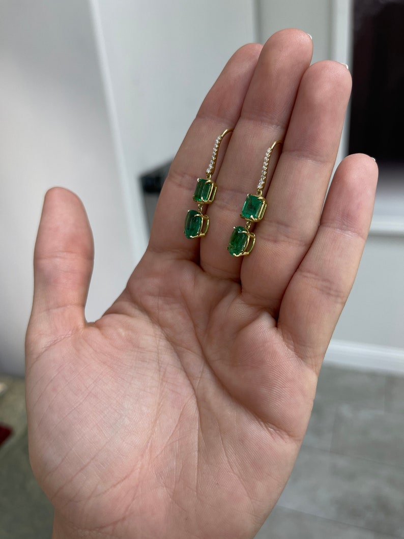 Colombian Emerald earrings with dark emerald accents and diamond details, featuring elegant dangle design in 18K gold.