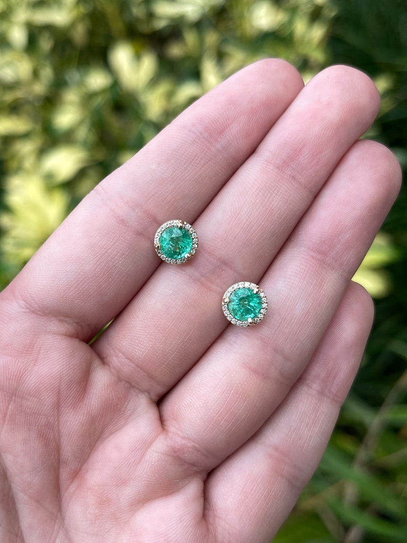 14K gold round emerald and diamond halo stud earrings, 8.5mm size, featuring Colombian emeralds and sparkling diamonds.