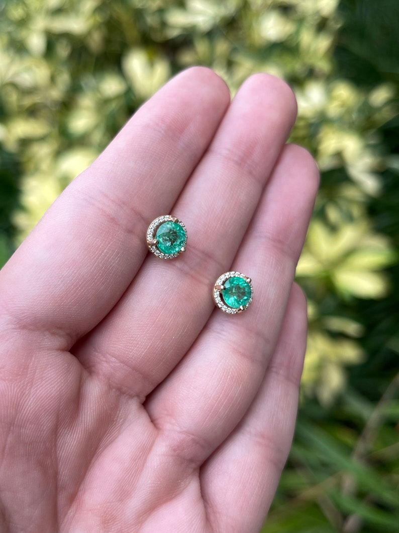 14K gold round emerald and diamond halo stud earrings, 8.5mm size, featuring vibrant Colombian emeralds and sparkling diamonds.
