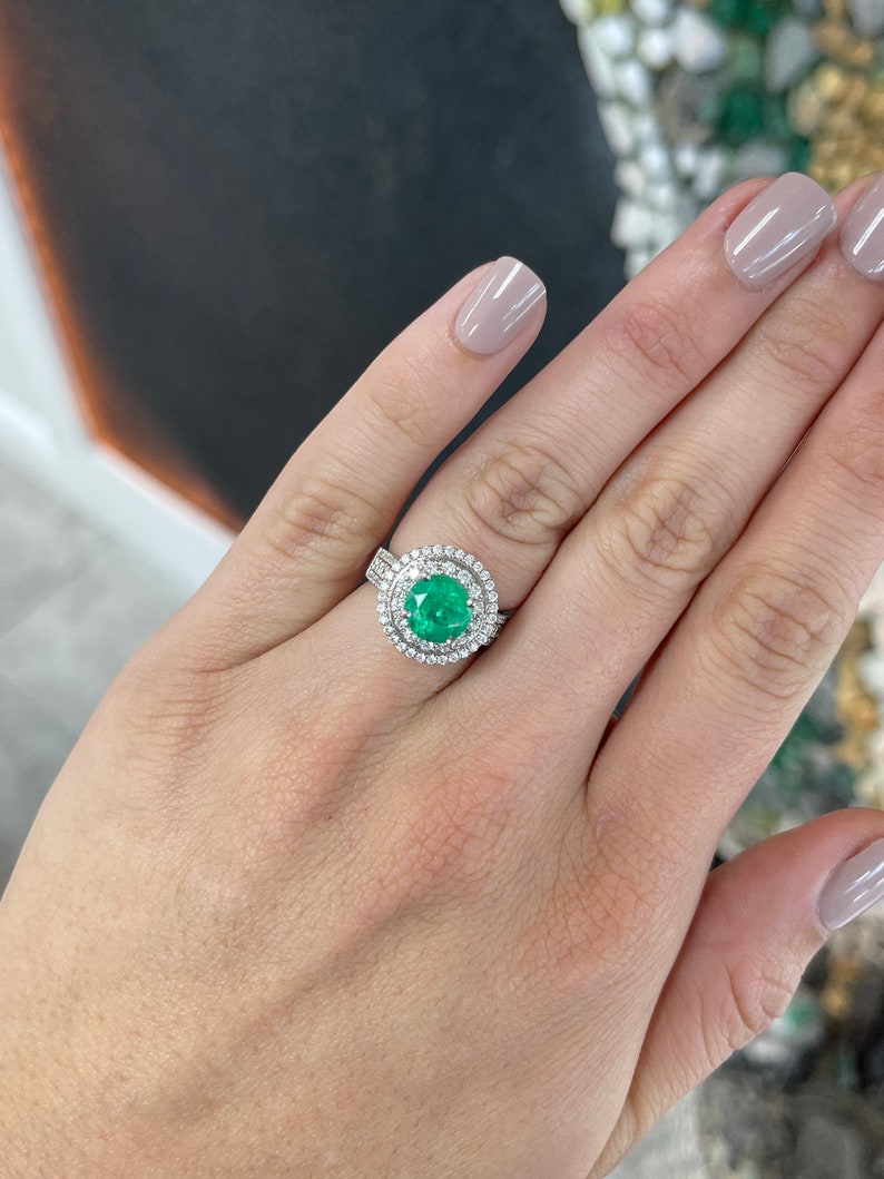 Colombian Emerald engagement ring with 3.52tcw round emerald center, halo of diamonds, 14K white gold setting.