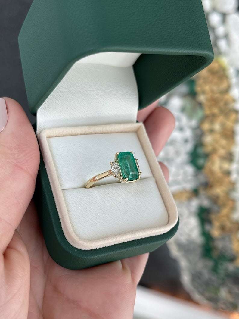 Colombian Emerald engagement ring featuring a 4.20tcw medium bluish green emerald and marquise cut diamonds in 14K setting
