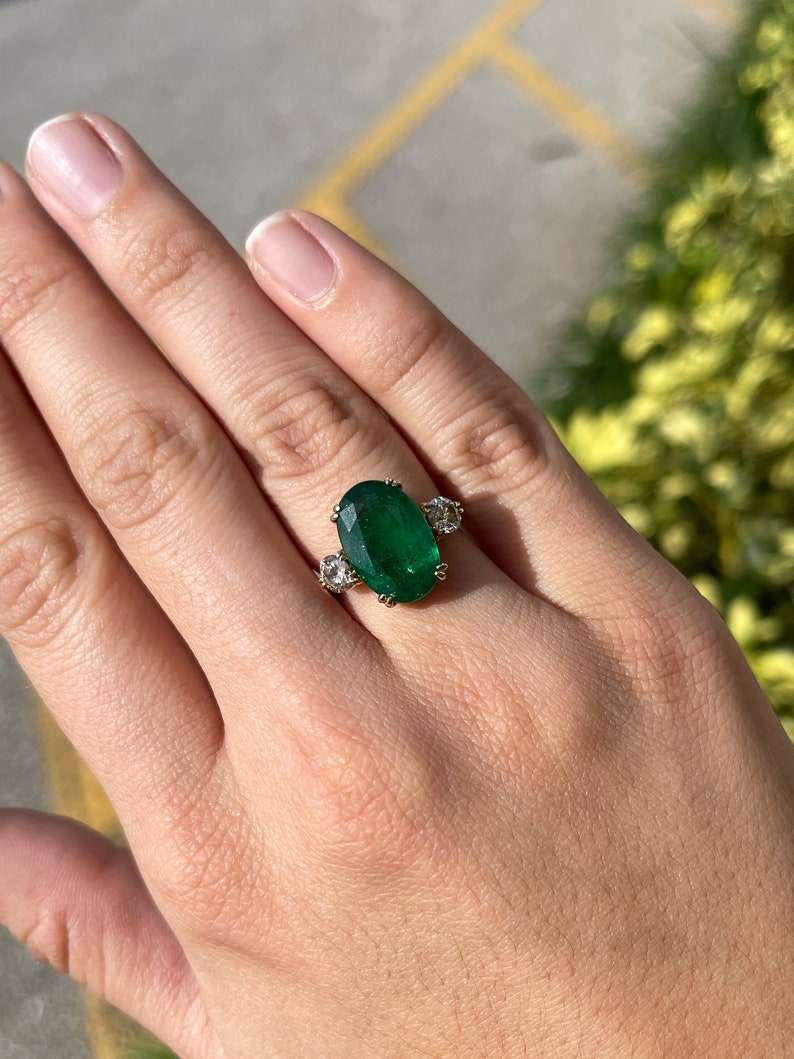 Dark green oval emerald and round diamond 3-stone engagement ring in 14K gold, featuring double prong setting by Colombian Emerald.