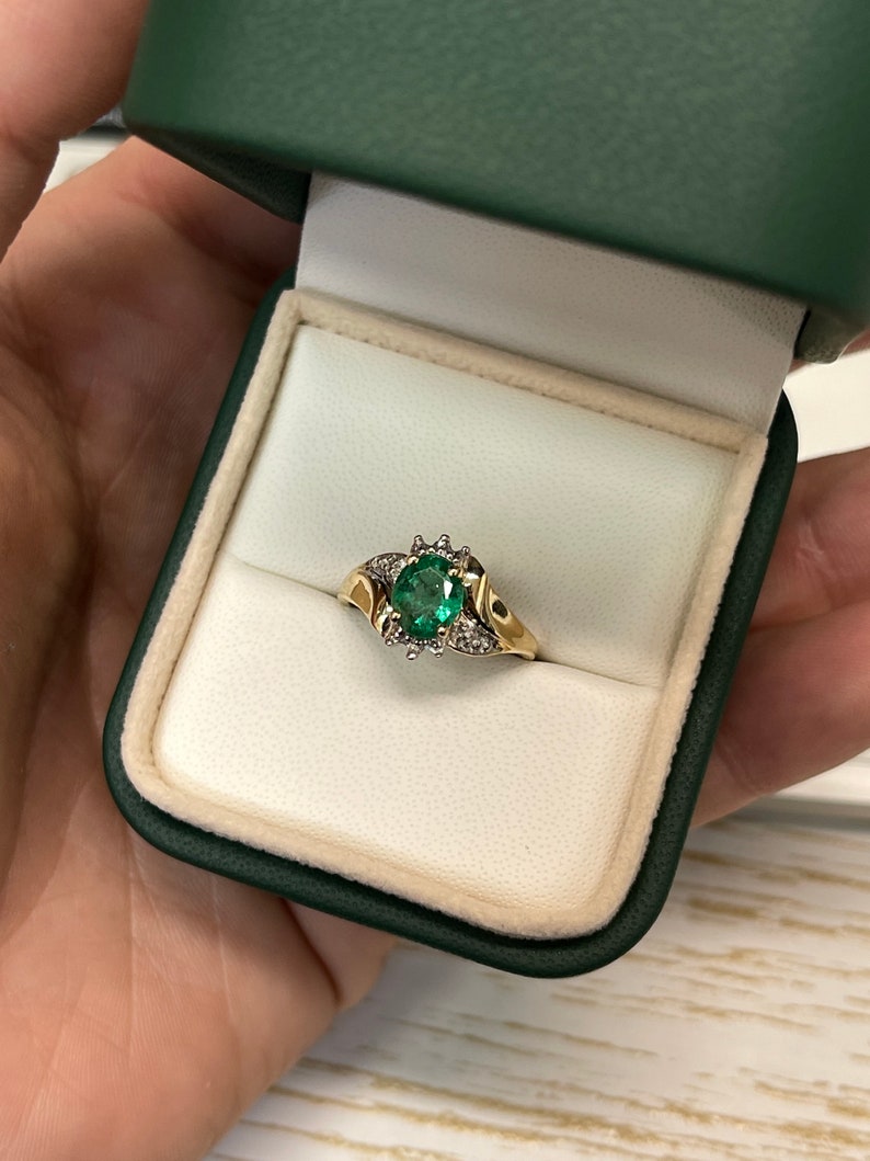 Ladies emerald ring featuring a 1.81 carat oval cut dark green emerald with diamond accents in 14K gold by Colombian Emerald.