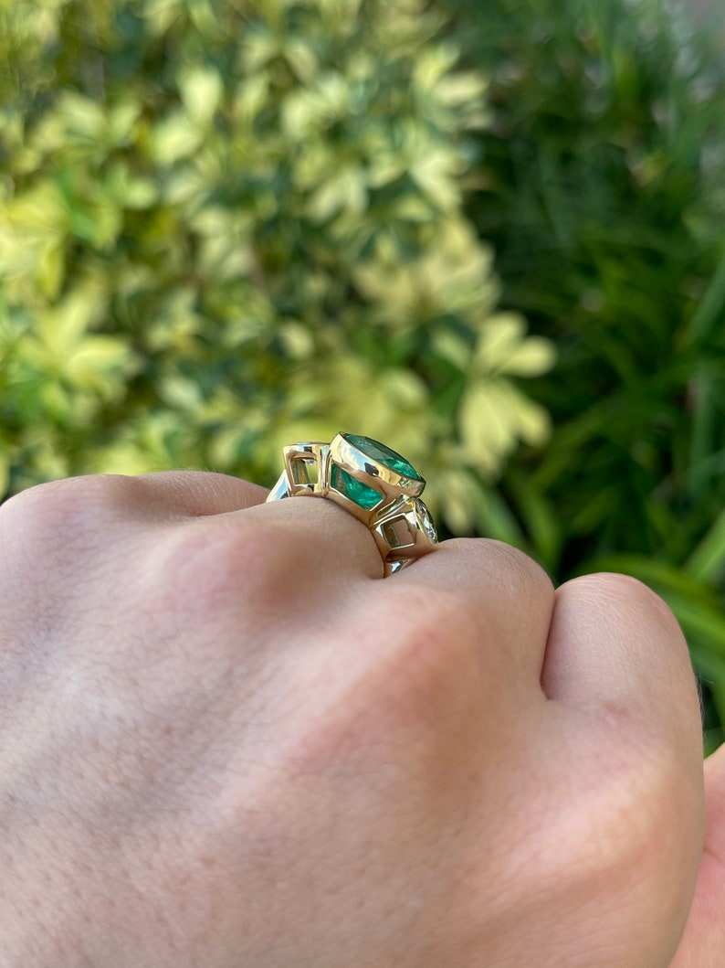 Ladies 18K gold three-stone ring featuring 6.50tcw Colombian Emeralds and VS diamonds, elegant jewelry design