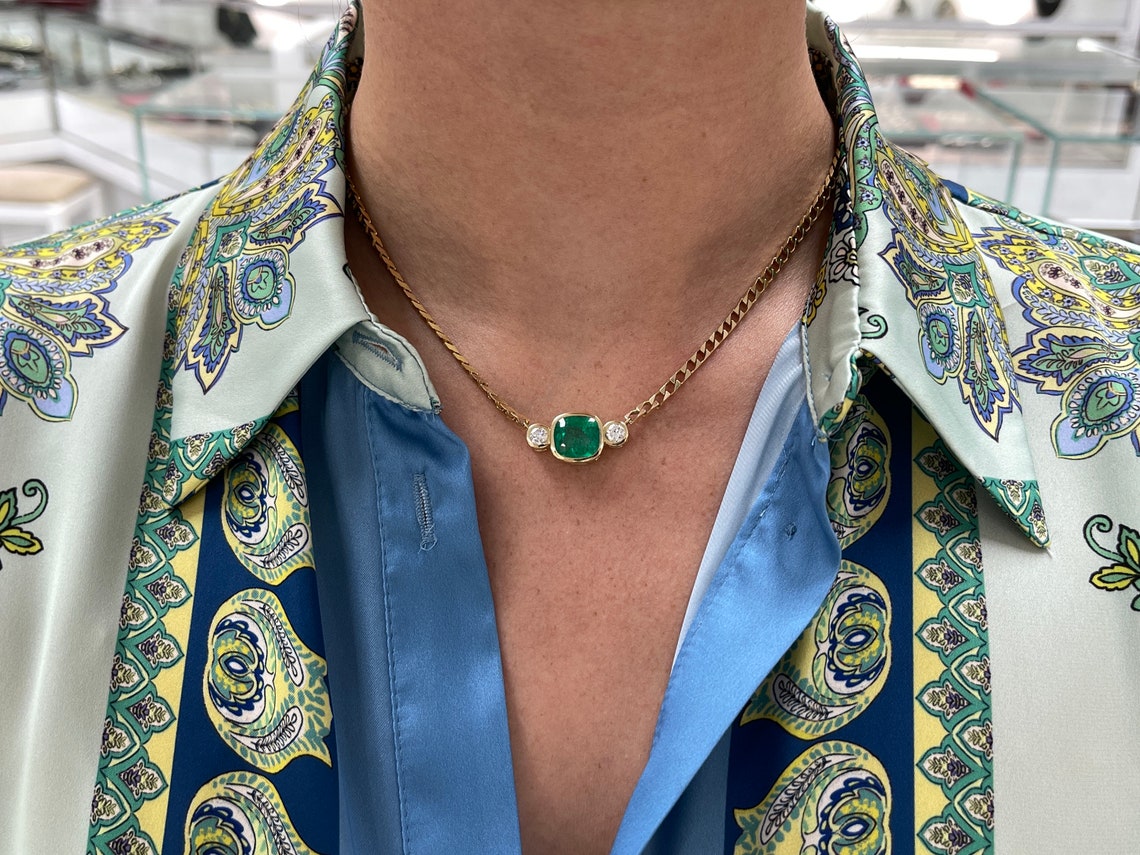 Dark green Colombian emerald and diamond three-stone necklace with cushion cut emeralds on 14K curb chain.