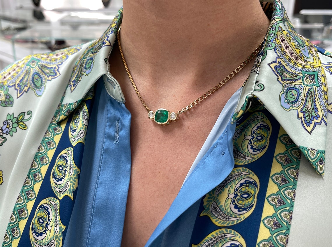 Dark green Colombian emerald cushion cut and diamond three-stone necklace on 14K curb chain, featuring 5.24 carats of gemstones.