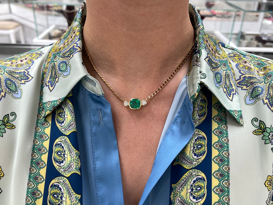 Dark green Colombian emerald and diamond three-stone necklace with cushion cut emeralds on 14K curb chain.