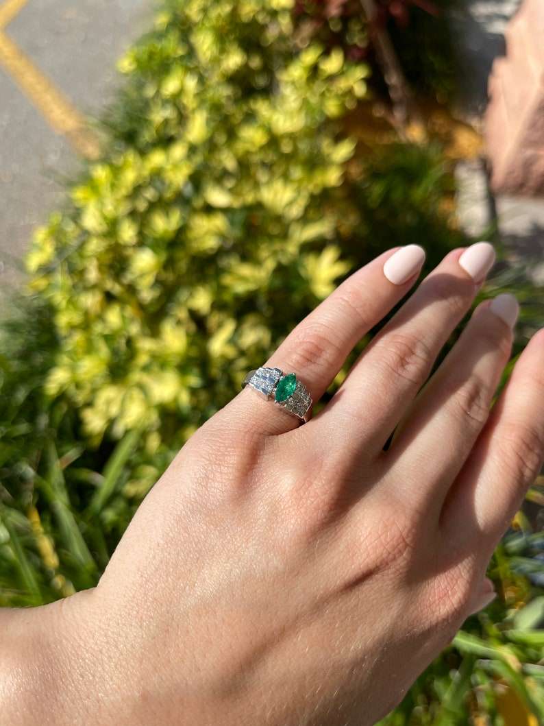 Colombian Emerald marquise diamond cocktail ring with platinum band, semi-transparent design, measuring 0.88 carats.