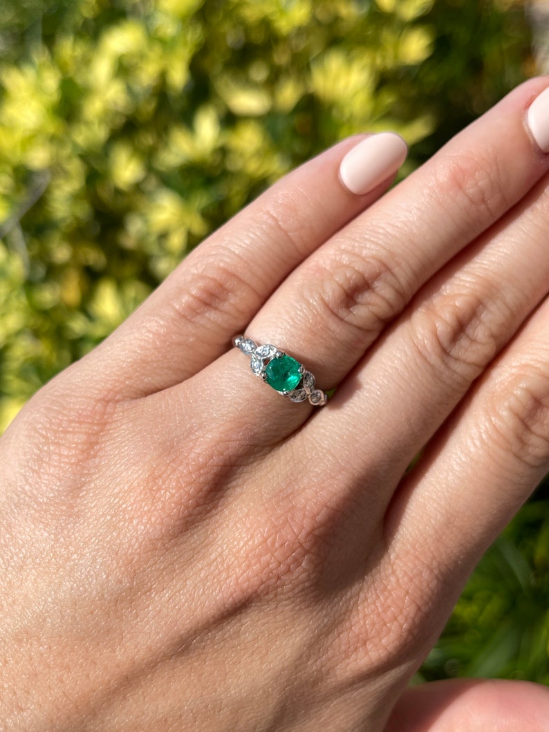 14K Colombian Emerald and diamond floral ring with round-cut stones, featuring a 0.96 carat total weight, elegant jewelry piece.