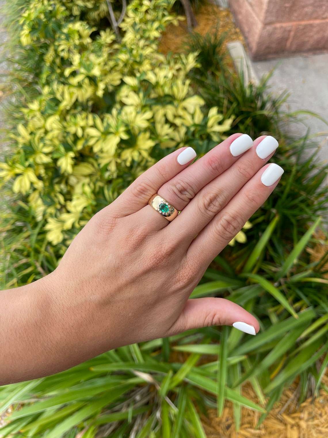 14K Colombian Emerald and diamond halo accent band ring featuring an oval cut emerald, 1.08 tcw, with intricate design.