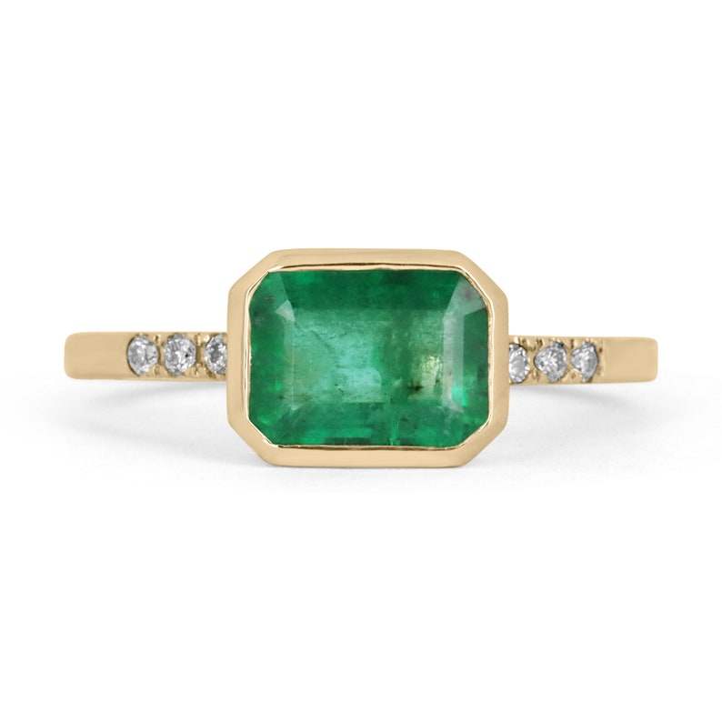 Colombian Emerald 14K ring featuring a 1.15tcw emerald cut green emerald with diamond accents in a bezel setting