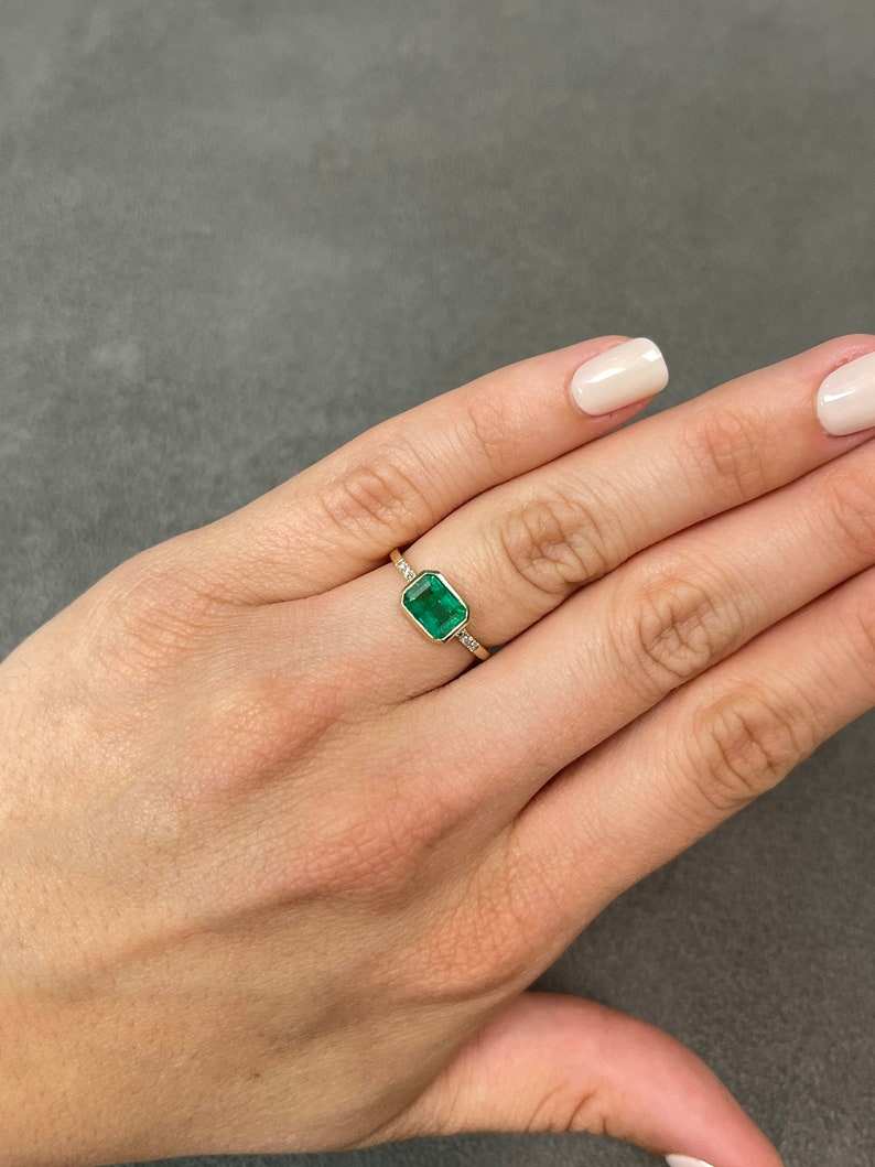 Colombian Emerald private link ring featuring a 1.15 tcw natural emerald cut emerald with diamond accents in a 14K bezel setting