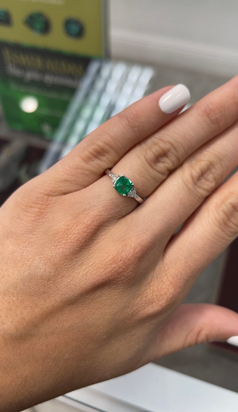 18K Colombian Emerald and diamond three-stone cushion cut ring with 1.48tcw total weight, featuring vibrant green emeralds and sparkling diamonds