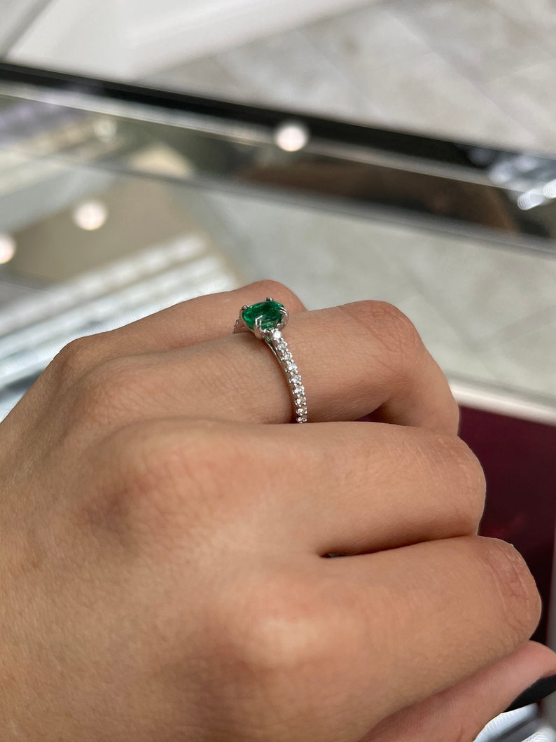 Oval cut natural emerald and diamond engagement ring in 14K white gold, featuring Colombian emeralds and elegant design.