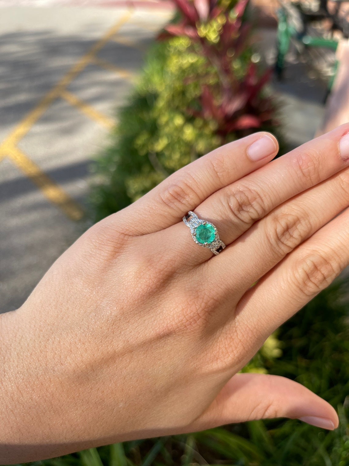Round Colombian emerald and diamond halo engagement ring in 14K gold with 1.57tcw, featuring intricate jewelry design.