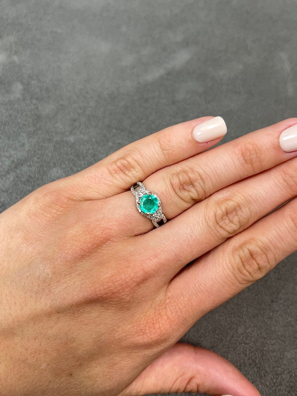 Round Colombian emerald and diamond halo engagement ring in 14K gold with 1.57tcw total weight, showcasing intricate design and sparkle.