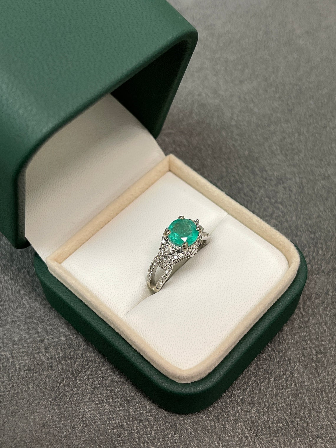14K Colombian Emerald and Diamond Halo Engagement Ring with 1.57tcw round emerald centerpiece and intricate detailing.