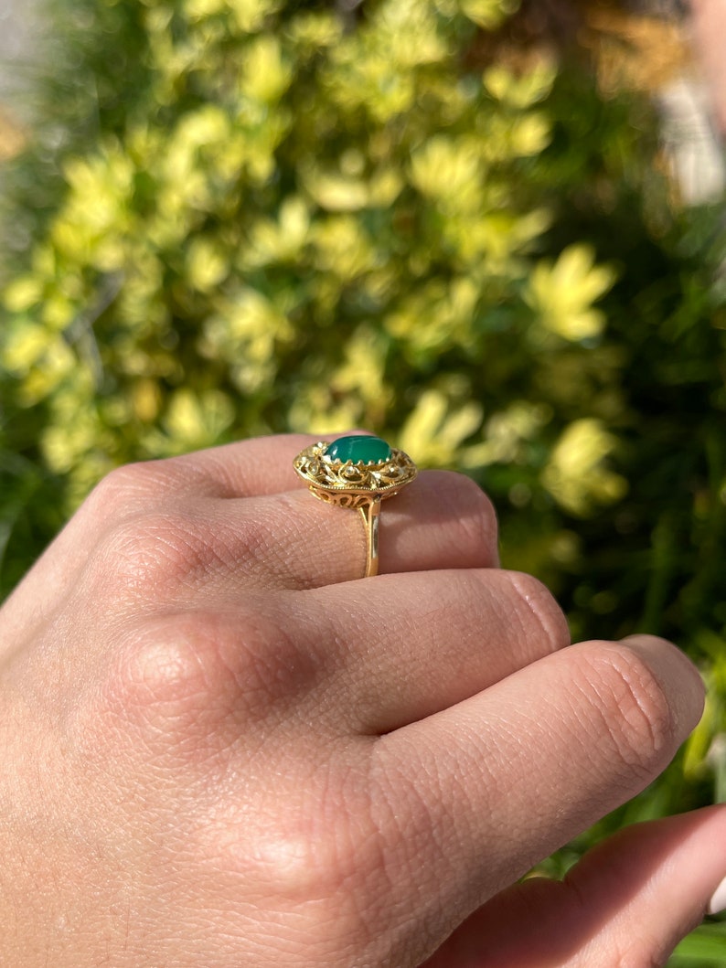 Colombian Emerald 2.03cts natural elongated oval cabochon floral antique ring in 18K gold, showcasing intricate handmade design.