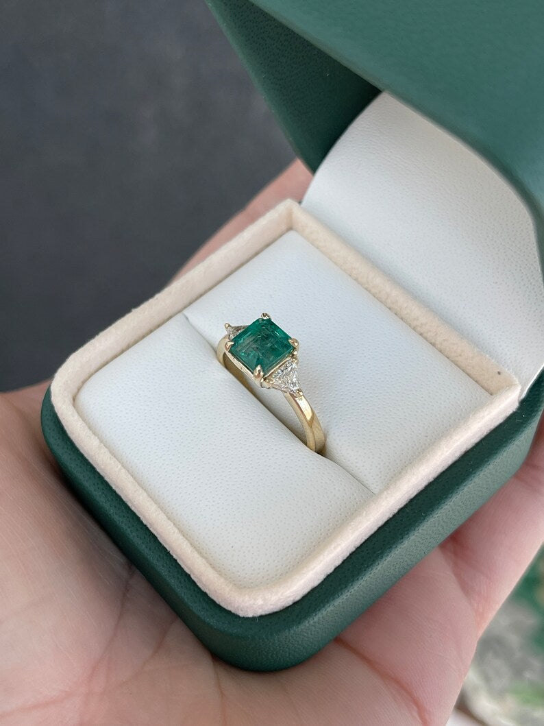 14K gold 3-stone engagement ring with lush green Asscher emerald and trillion cut diamond accents, featuring a 2.0 tcw design.
