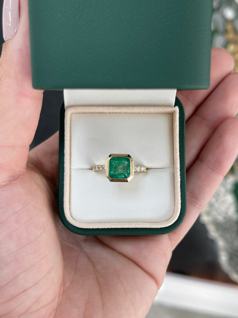 14K gold square emerald and diamond accent right hand solitaire ring with Asscher cut emerald and bezel setting by Colombian Emerald