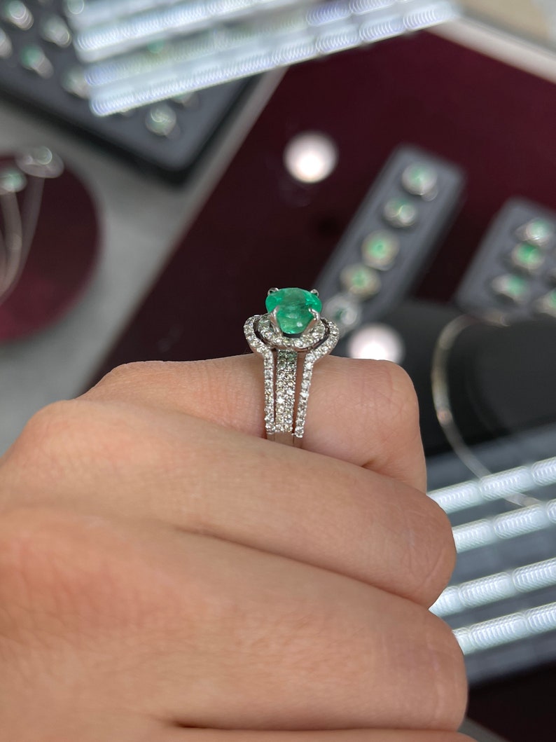 14K Colombian Emerald and diamond halo engagement ring featuring a round cut emerald and sparkling diamonds set in a elegant ring