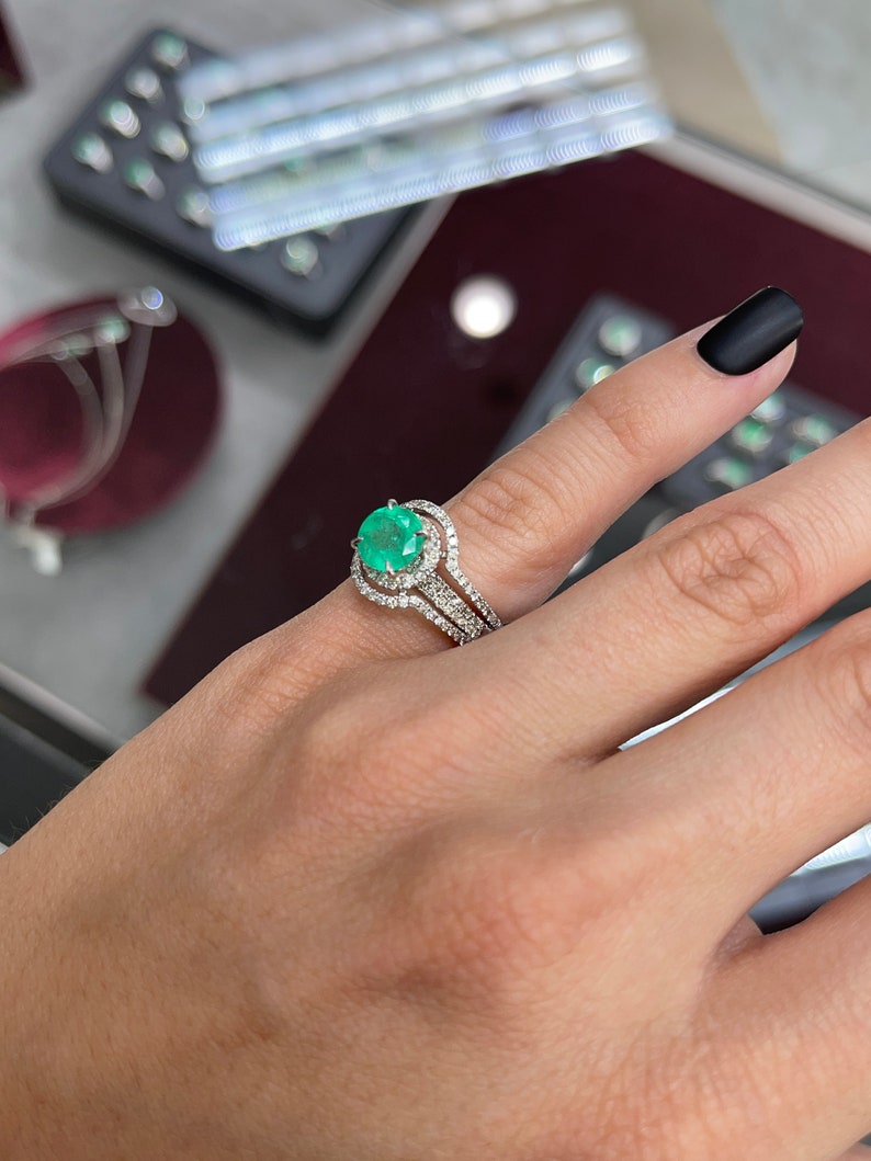 14K Colombian Emerald and diamond halo engagement ring with round cut emerald and sparkling diamonds in a detailed setting