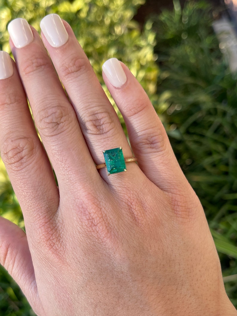 18K gold emerald cut solitaire engagement ring with a 3.84-carat Colombian emerald gemstone.