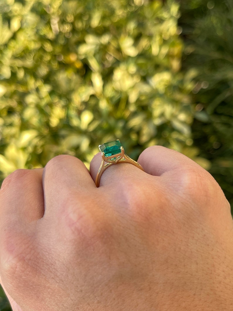 18K gold emerald cut solitaire engagement ring with a 3.84 carat Colombian emerald, showcasing a classic and elegant design.