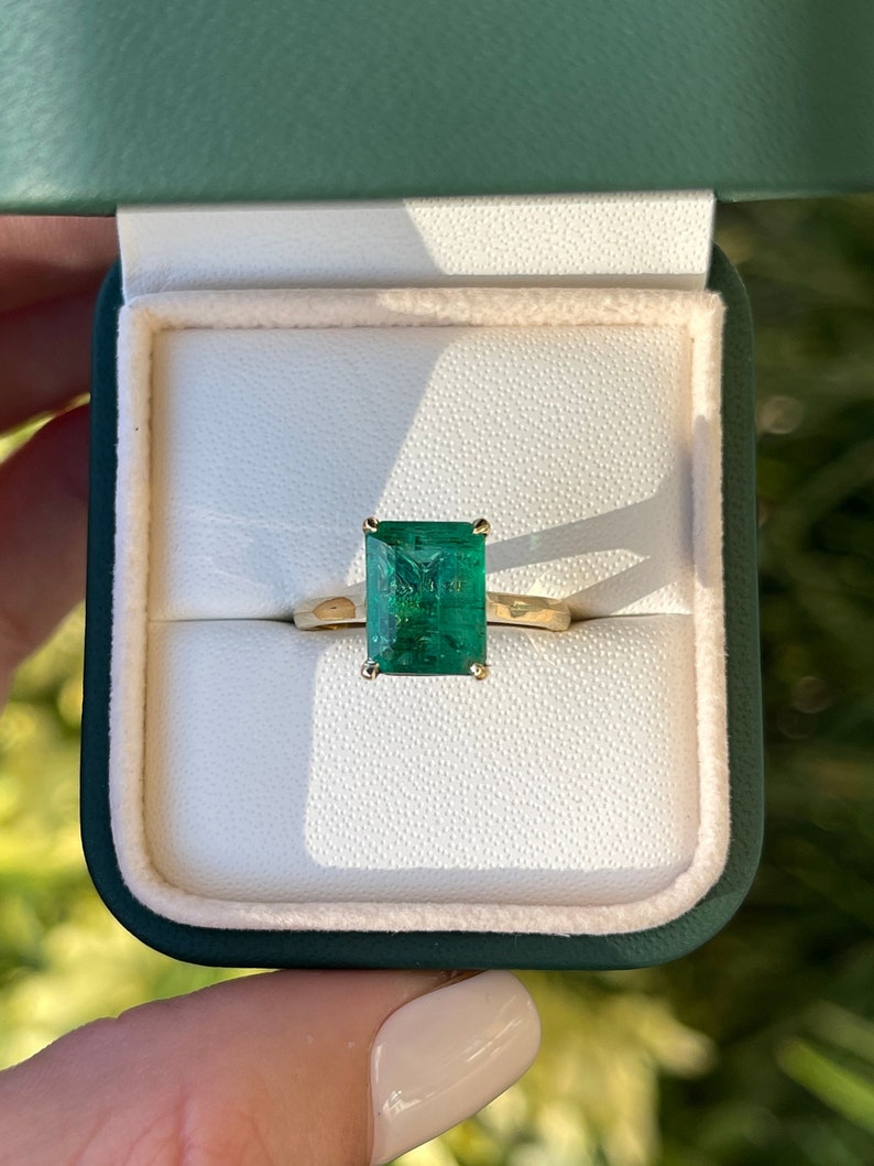 18K gold emerald cut solitaire engagement ring with a 3.84-carat Colombian emerald gemstone, showcasing a classic and elegant design.