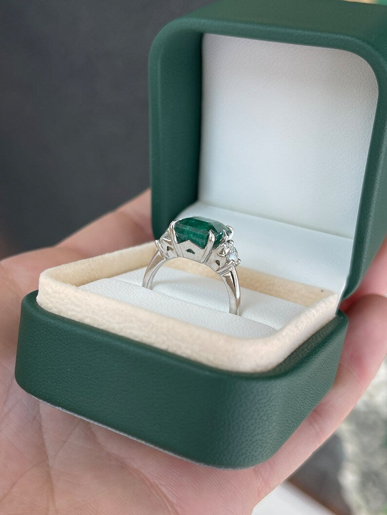14K gold 3-stone engagement ring with intense dark green emerald and round diamonds by Colombian Emerald, featuring Asscher cut center stone.