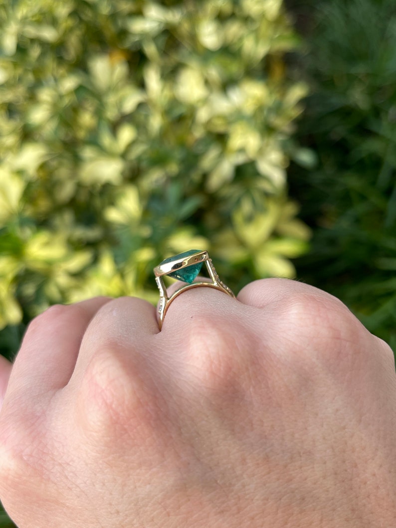 Dark green natural oval cut emerald gold ring with diamond accents, 18K bezel setting, Colombian Emerald brand, jewelry ring.