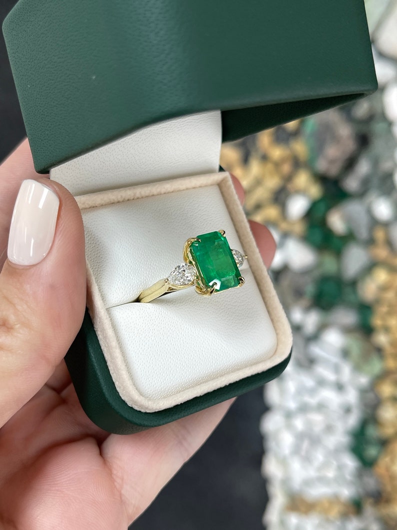 18K gold 3-stone diamond ring with emerald and pear-shaped diamonds, featuring a luxurious crazy rich design by Colombian Emerald.