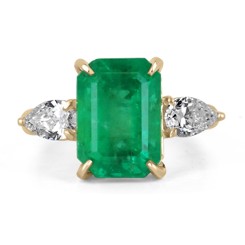 18K gold three-stone diamond ring with emerald and pear-shaped diamonds, featuring a luxurious, intricate design by Colombian Emerald.
