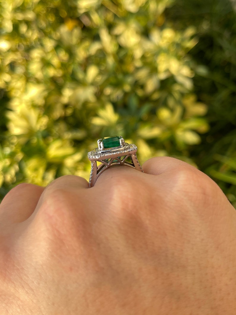 Colombian Emerald 7.39tcw 18K white gold triple diamond halo anniversary ring with emerald and diamond accents.