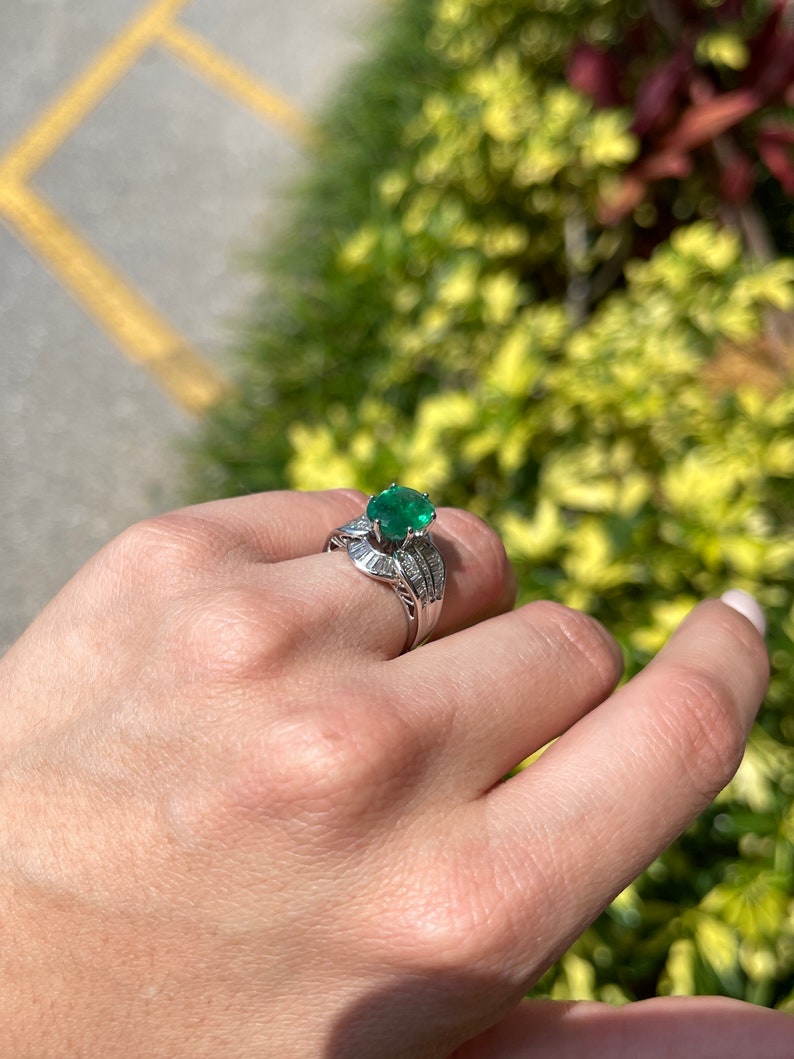 Antique Colombian Emerald and diamond ring featuring a 3.77tcw oval cut emerald set in 18K white gold.