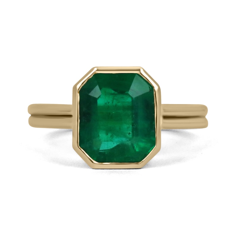 3.20 carat emerald-cut Muzo emerald bezel engagement ring in 18K yellow gold double shank setting